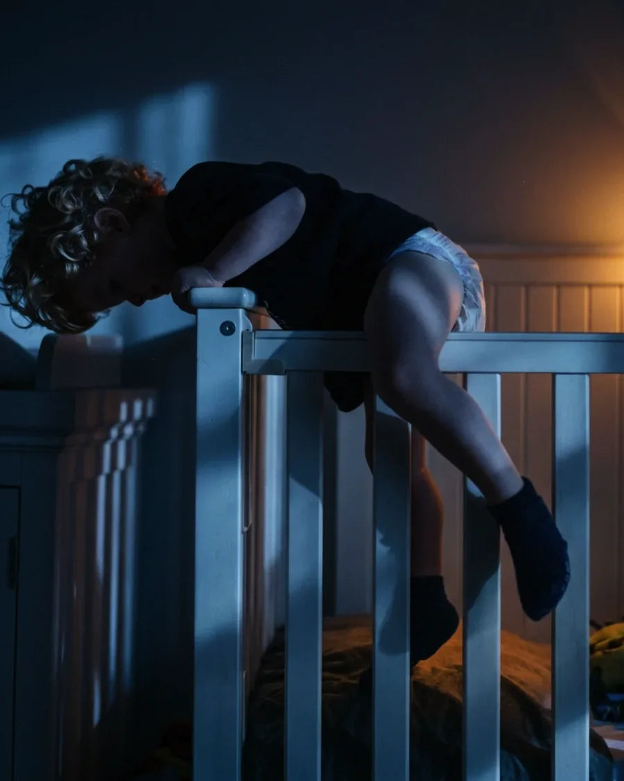 Toddler climbing out of a cot at night