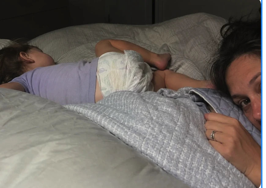 Child sleeping next to a parent at night